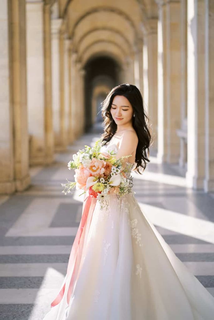 Bride holding a flower bouquet at Mus&eacute;e du Louvre during sunrise time